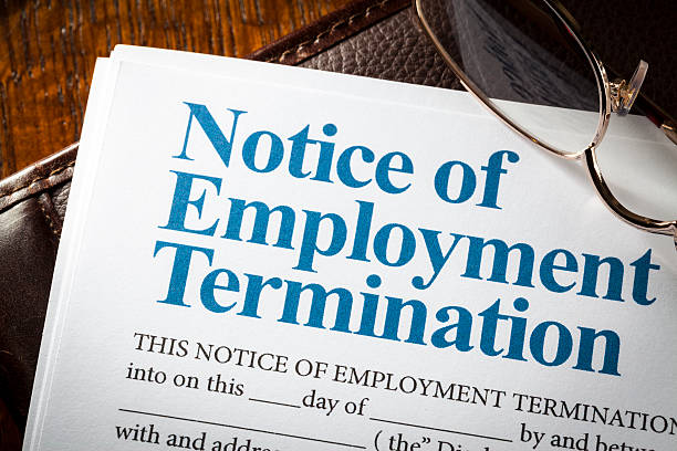 Notice of employment termination with pen on note pad and desk